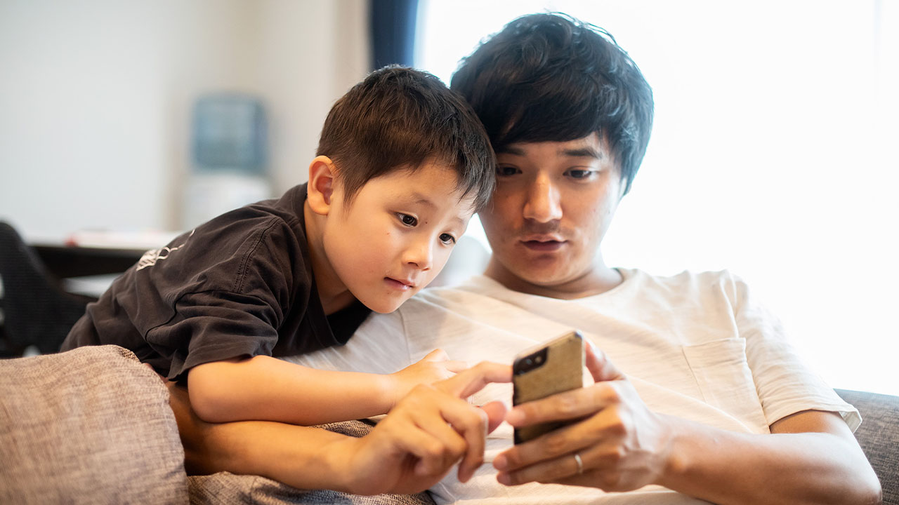 スマホを見ている親子の写真
